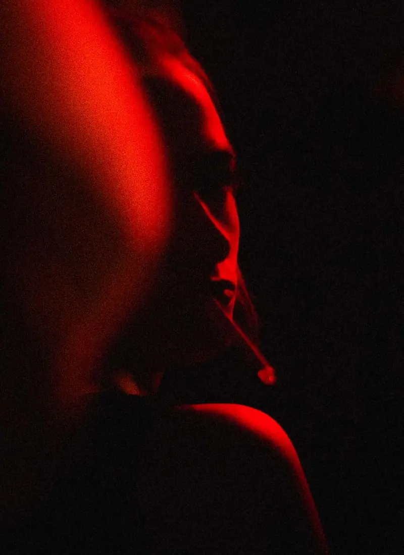 Profile in red light, smoke. Photo by Iheb Fehri