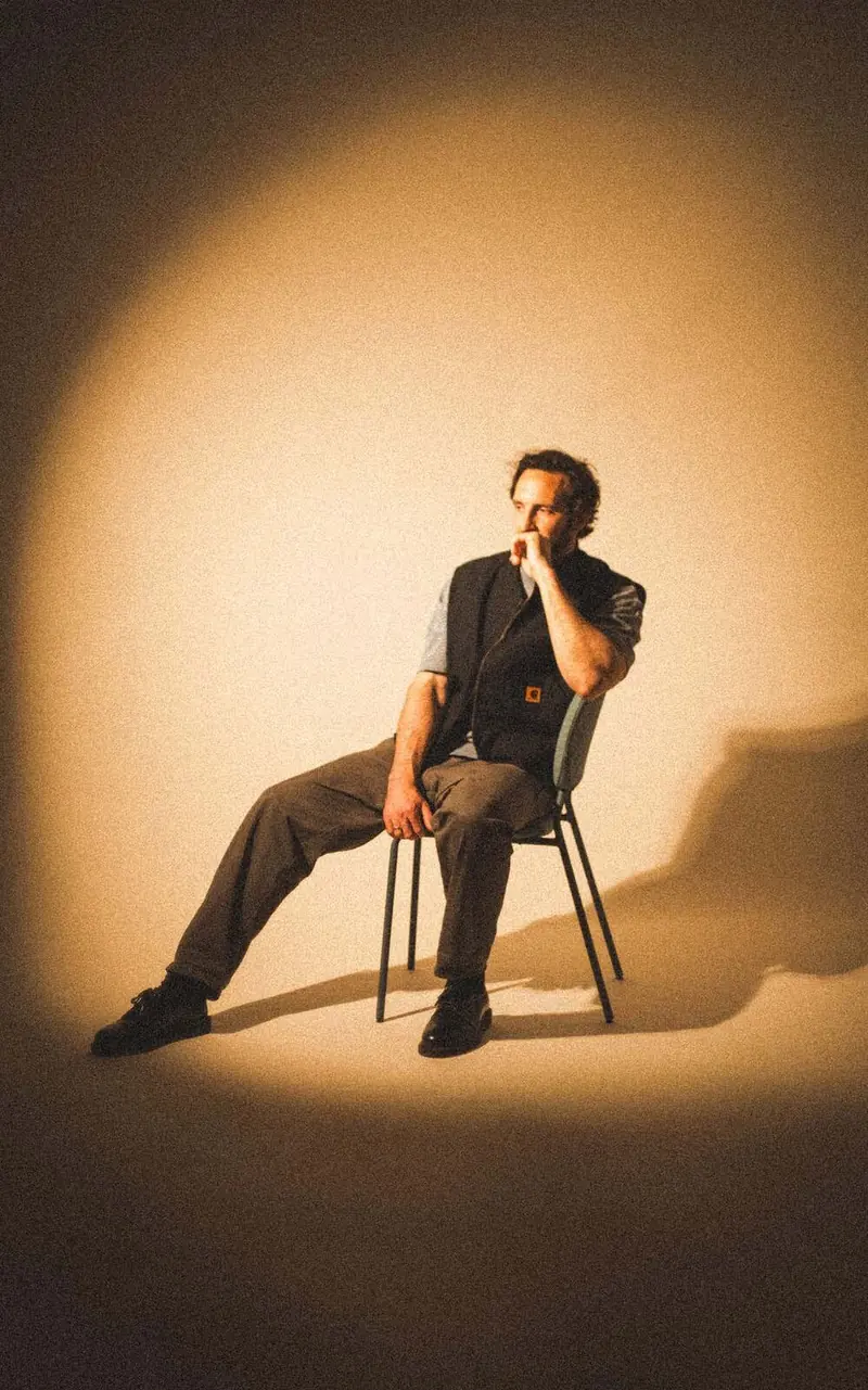 Man seated in a spotlight, Gaspero, My studio, 2026. Photo by Iheb Fehri